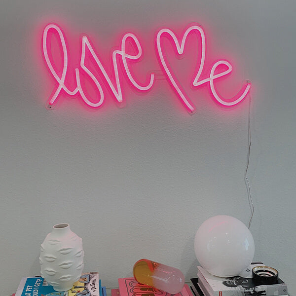 Pink love me neon sign  hanged on a wall